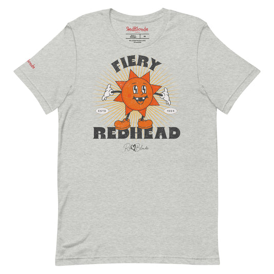 Heather grey unisex crew neck t-shirt with a bold retro graphic of a smiling orange cartoon sun character, surrounded by radiant sunbeams. The text reads ‘Fiery Redhead’ in distressed black Belzebuth lettering with small details including ‘ESTD 1994’ and the RedBlonde signature logo beneath."