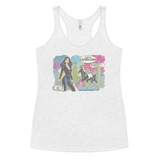 Flatlay of a heather white soft racerback tank t-shirt with a retro pop-art Capricorn graphic featuring a black haired woman in a black catsuit, carrying a bag, with a goat  and a city skyscraper backdrop, captioned ‘Just a Capricorn, Building an empire'