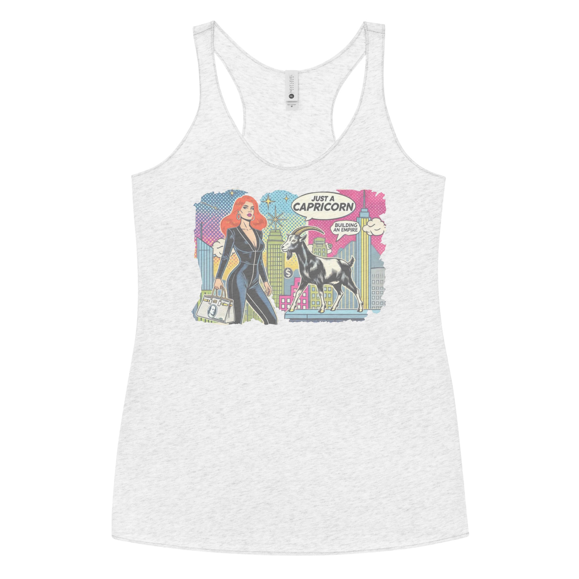 Flatlay of a heather white soft racerback tank t-shirt with a retro pop-art Redhead Capricorn graphic featuring a redhead woman in a black catsuit, carrying a bag, with a goat  and a city skyscraper backdrop, captioned ‘Just a Capricorn, Building an empire'