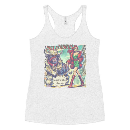 Flatlay of a heather white soft racerback tank t-shirt with a retro pop-art taurus graphic featuring a redhead woman with long flowing straight hair, wearing a green dress with a red belt, red high-heeled boots and red fur coat, walking a furry bull with a red collar and medallion in city street captioned ‘Just a taurus leading the charge'