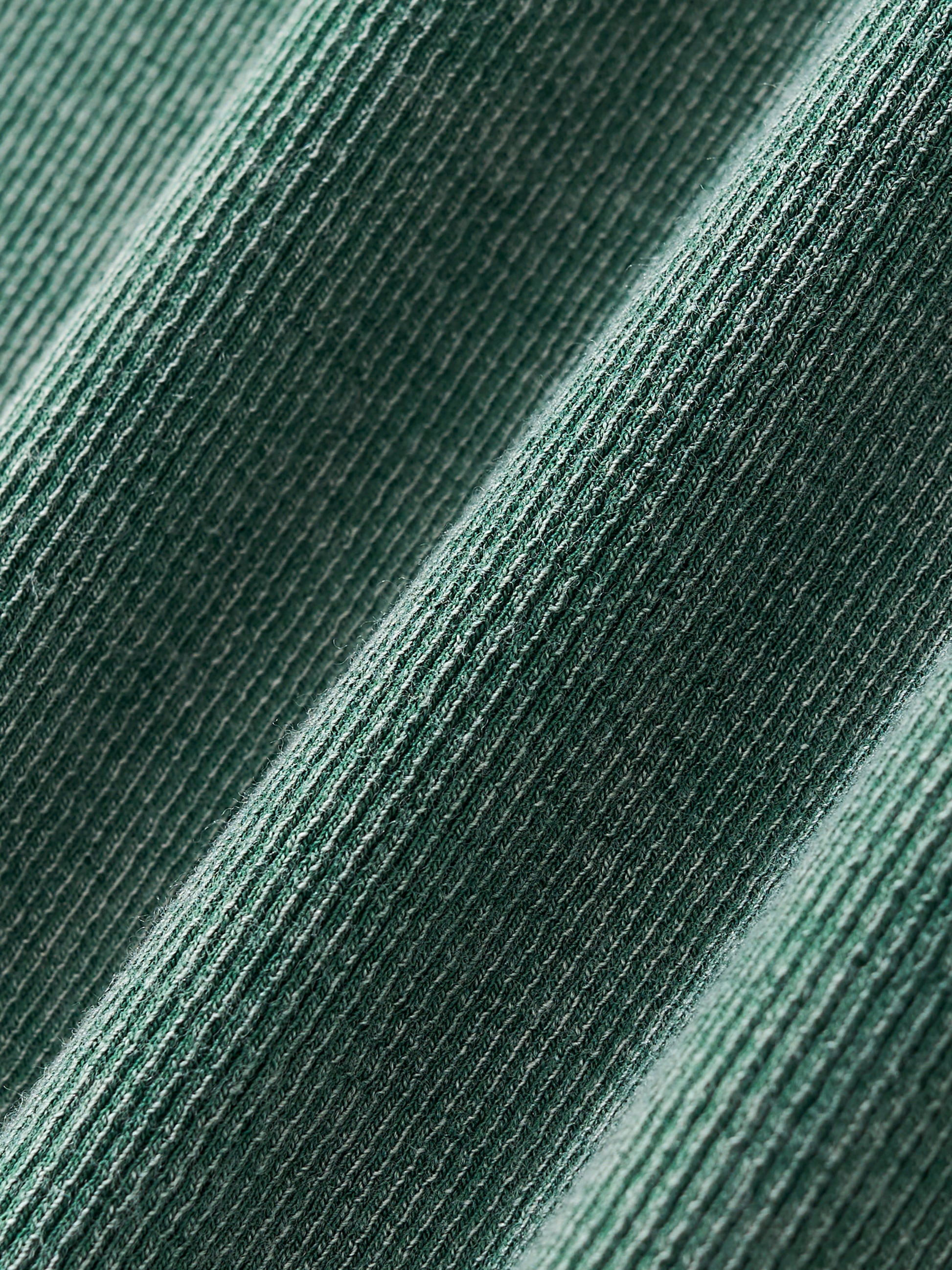 Close-up of textured green fabric with a subtle ribbed texture pattern