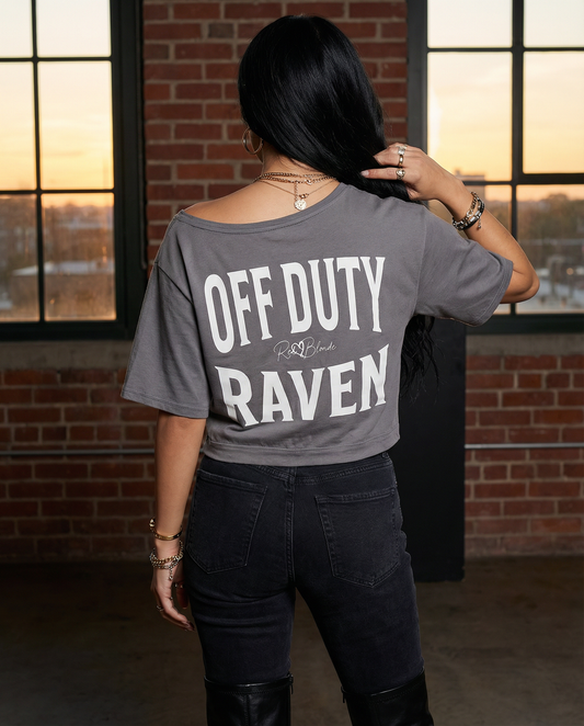 model wears a black asymmetrical boxy T-shirt with white ‘OFF DUTY RAVEN  brookfield text back print and RedBlonde signature logo.”