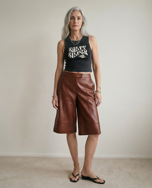 model wears a Black sleeveless crop tank top with a high neckline, featuring a white Solino Display retro-style “Salty Silver” font graphic across the chest and a RedBlonde London neck label