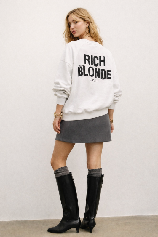 model wears a White oversized dolman-sleeve sweatshirt shown from the back on a plain white background. It has a boxy, relaxed fit with dropped shoulders, ribbed crew neckline, ribbed cuffs, and a ribbed hem band. Centered on the back is a distressed black “RICH BLONDE” Ed Gein graphic with a small “RedBlonde” script logo beneath.