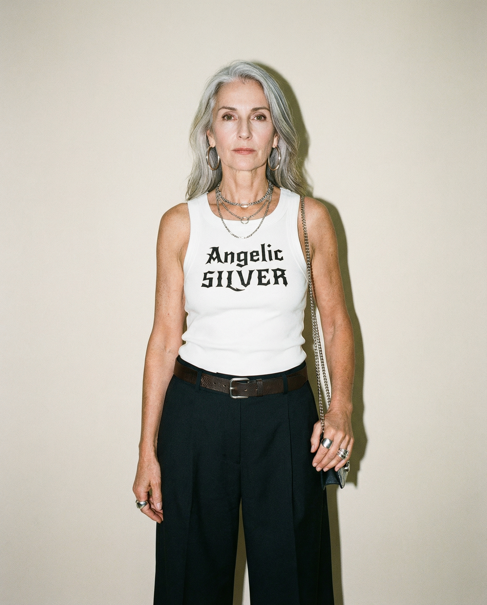 model wears white snow-washed tank t-shirt with black gothic New Rockstar text reading “Angelic Silver” across the chest.