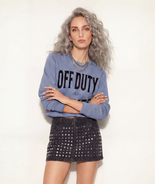 model wears a blue crewneck sweatshirt with a large black “OFF DUTY SILVER” graphic across the chest and a small RedBlonde script logo centered between the words.