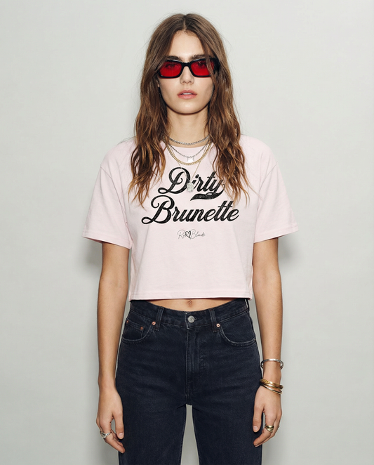 model wears brunette wears a orchard  women’s crop top featuring the phrase “Dirty Brunette” in bold, red milkstore vintage-style script across the chest. Below the phrase, the brand name “RedBlonde” is printed in a smaller, elegant handwritten font.