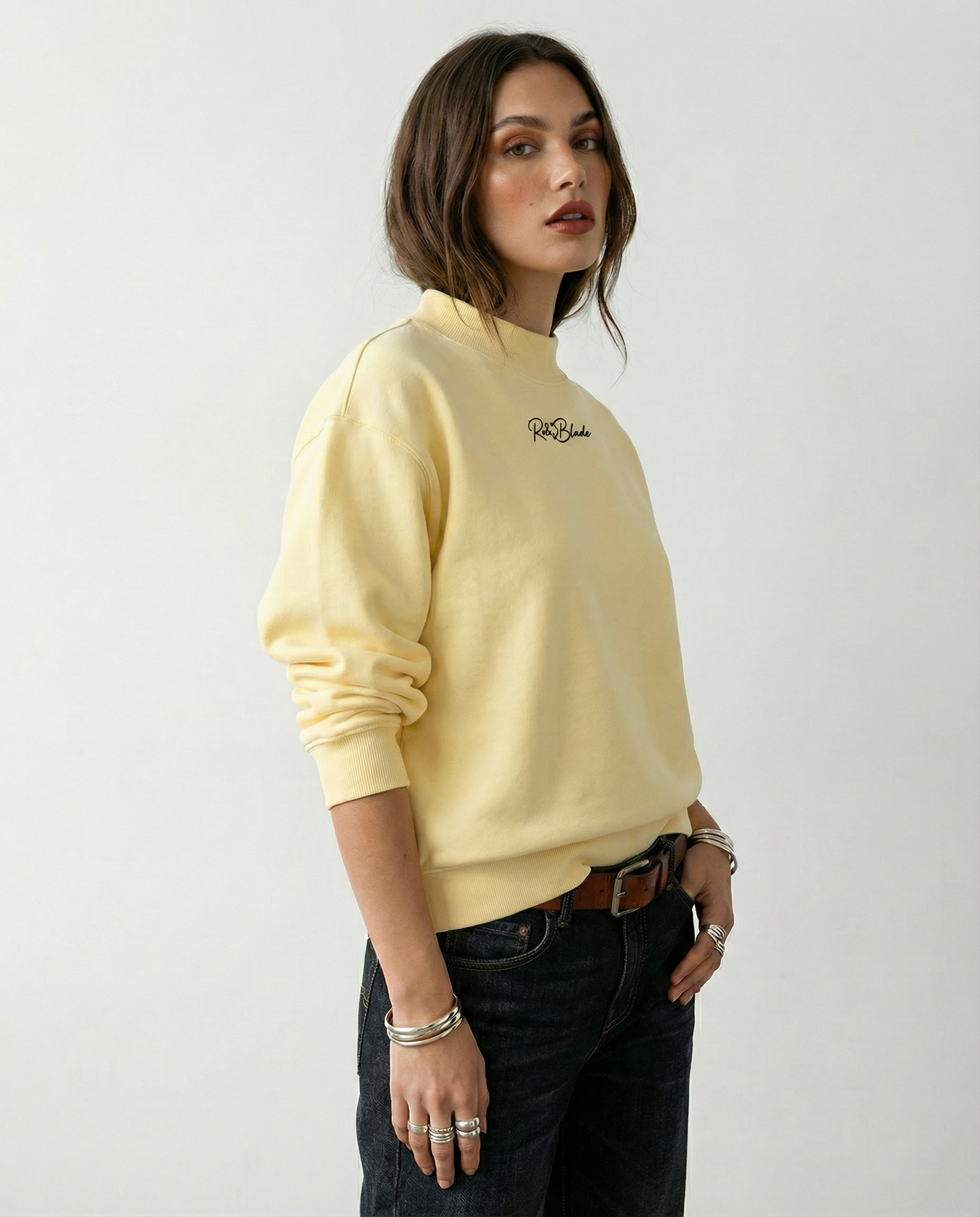 model wears Pale yellow oversized mock-neck sweatshirt with long sleeves, ribbed cuffs and hem, and a small RedBlonde logo printed at the centre chest.