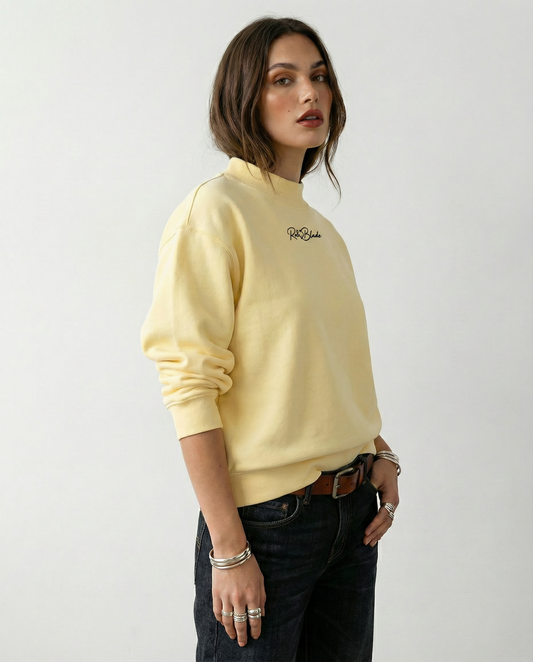 model wears Pale yellow oversized mock-neck sweatshirt with long sleeves, ribbed cuffs and hem, and a small RedBlonde logo printed at the centre chest.