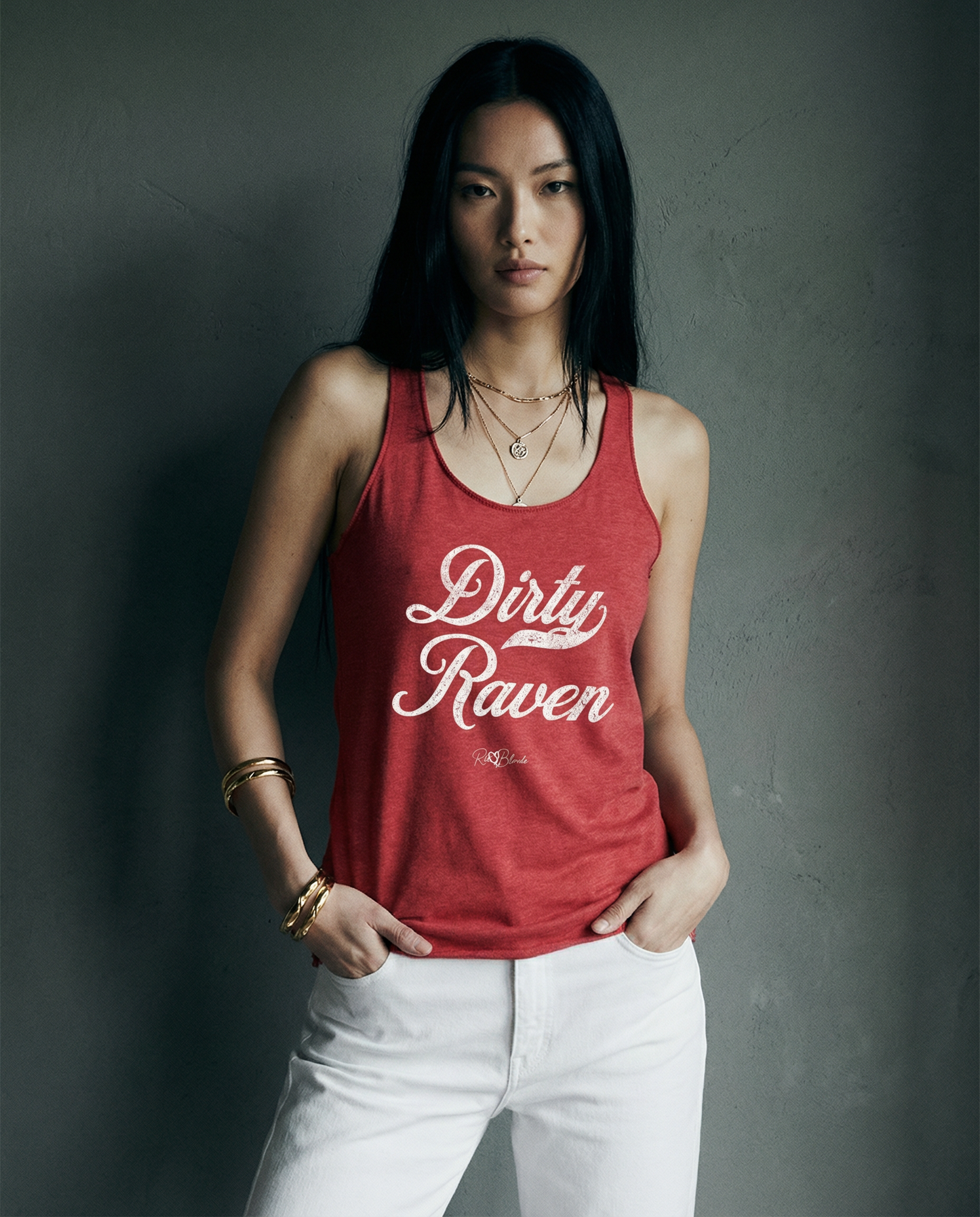 model wears a red women's racerback tank with the playful slogan ‘Dirty Raven’ in white milk-store font, signed off RedBlonde.
