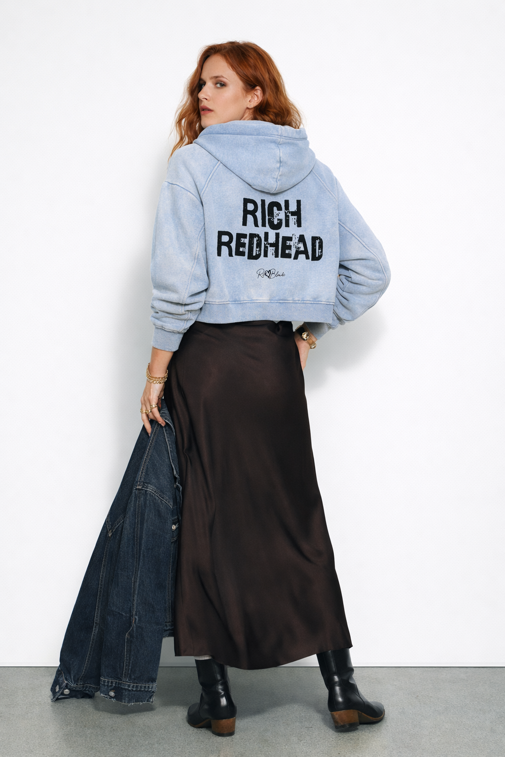 model wears a cropped snow-wash pale Blue hoodie with bold black “RICH REDHEAD” Ed Gein font and the RedBlonde signature logo printed below.