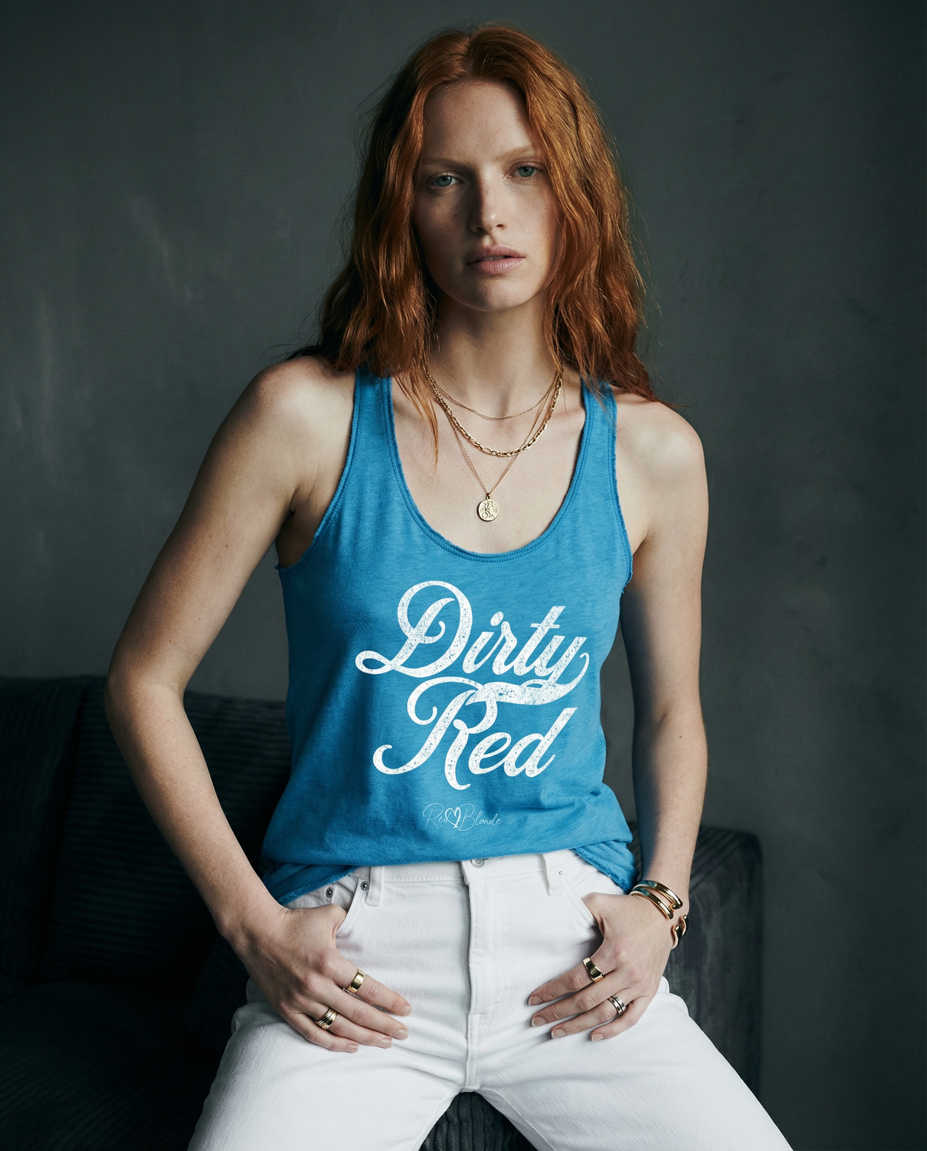 model wears a vintage turquoise women's racerback tank with the playful slogan ‘Dirty Red’ in white milk-store font, signed off RedBlonde. Branded RedBlonde London in red on the reverse