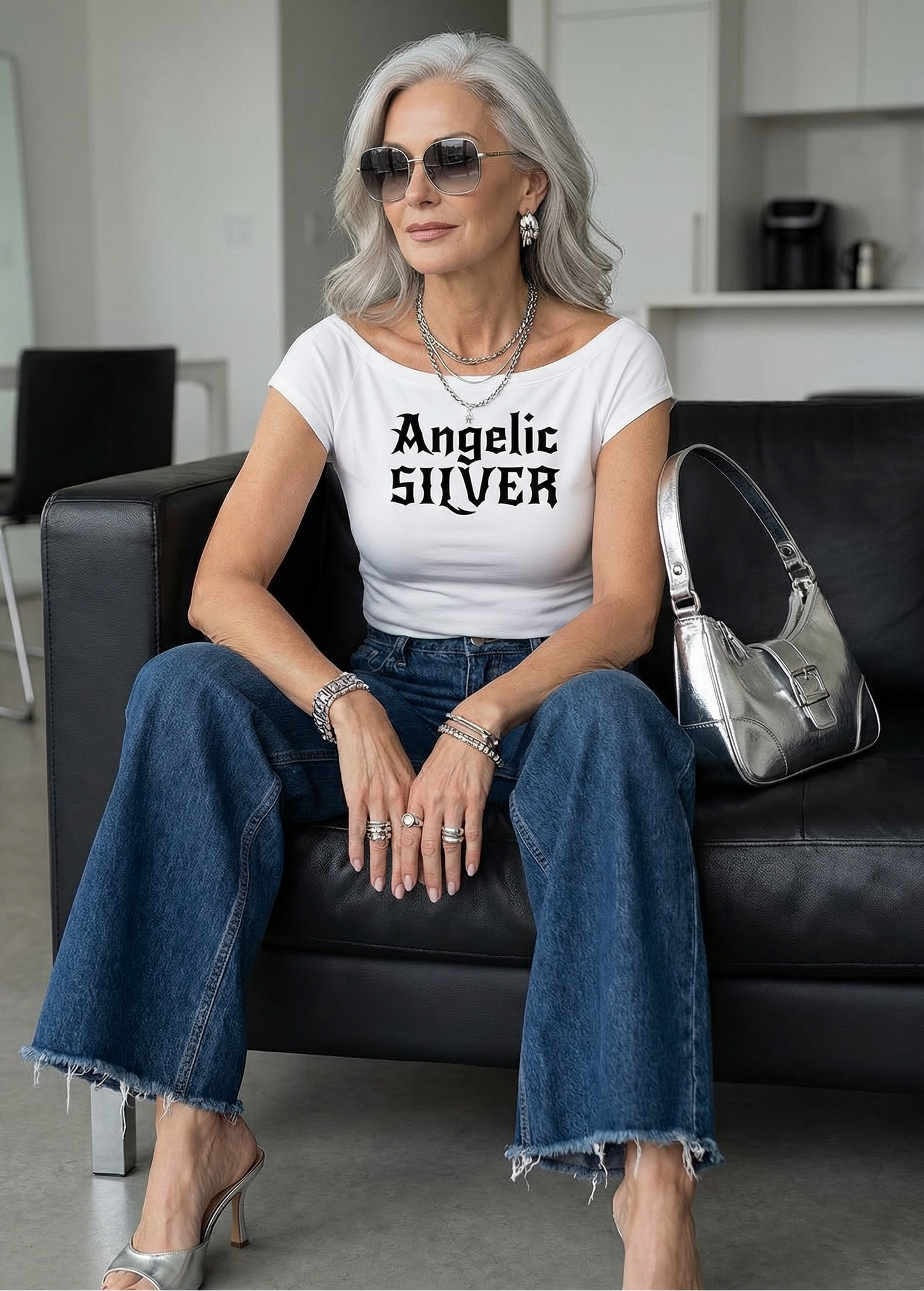 model wears a white wide-neck t-shirt with white gothic New Rockstar text reading “Angelic Silver” across the chest.