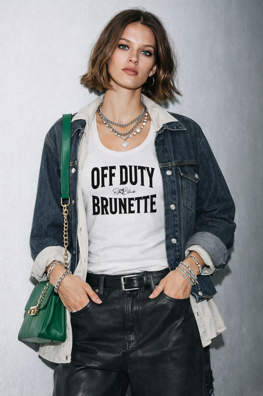 model wears a white sleeveless vintage acid wash tank top laid flat on a white background, with black text on the chest reading “OFF DUTY BRUNETTE” in bold Brookfield lettering, and a small cursive RedBlonde signature logo between the words. 