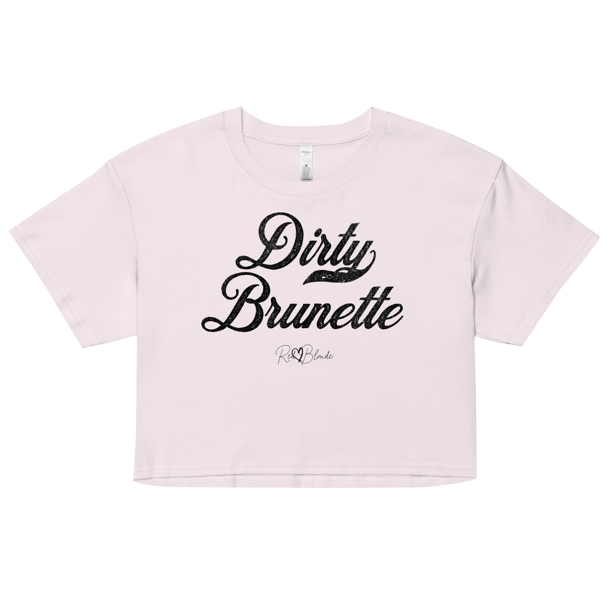 Orchid women’s crop top featuring the phrase “Dirty Brunette” in bold, black milkstore vintage-style script across the chest. Below the phrase, the brand name “RedBlonde” is printed in a smaller, elegant handwritten font.