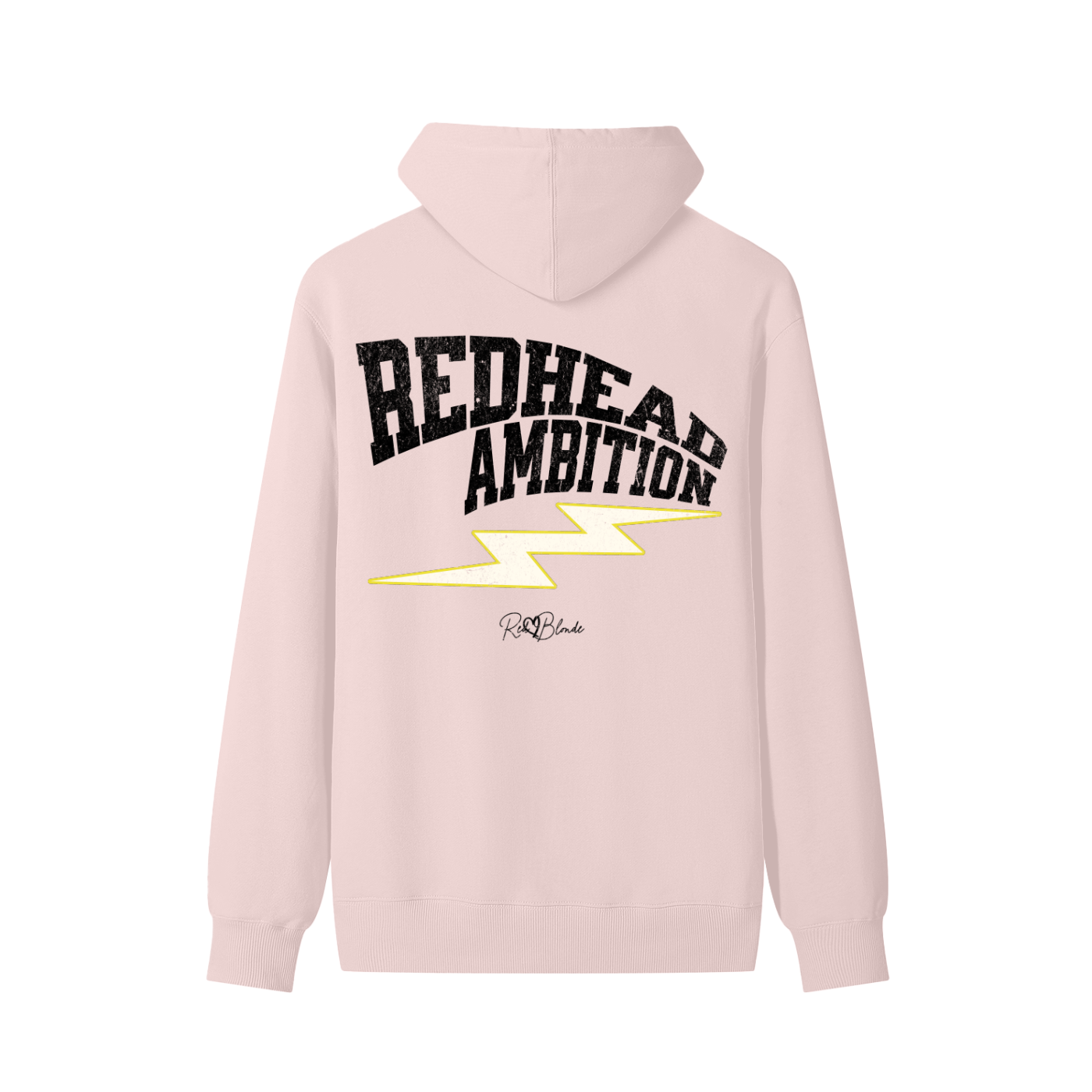 Pale pink hoodie featuring bold white vintage-textured TRICOT font lettering that reads “Redhead Ambition” across the back, with a yellow lightning bolt graphic underneath and the RedBlonde signature logo printed below.