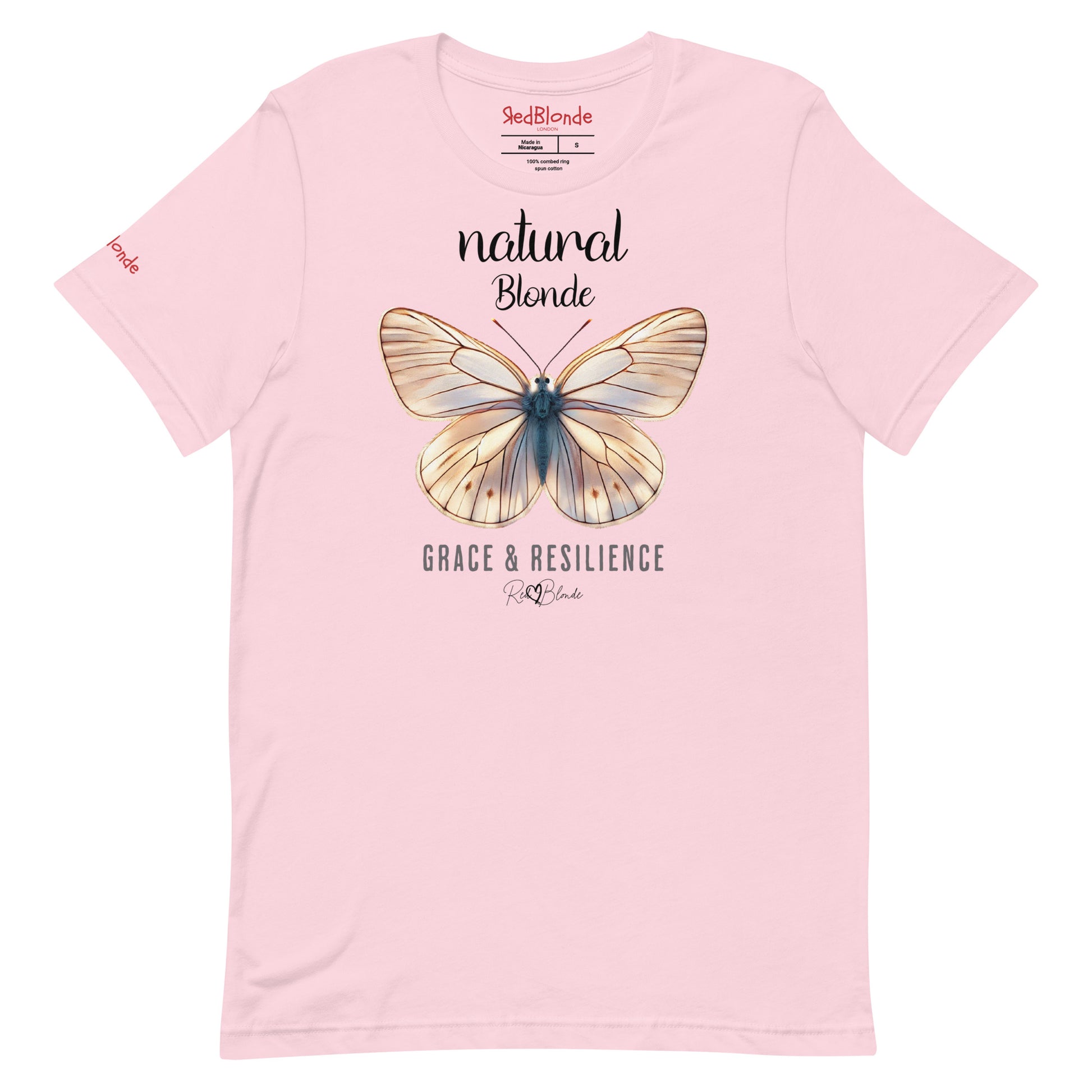 flatlay of a pale pink unisex relaxed fit t-shirt with the words natural blonde in arionna font above a graphic of a blonde butterfly with 'GRACE & RESILIENCE' below in  adventurer 06 font signed off by RedBlonde. Branded RedBlonde London in red on inside neck and right sleeve
