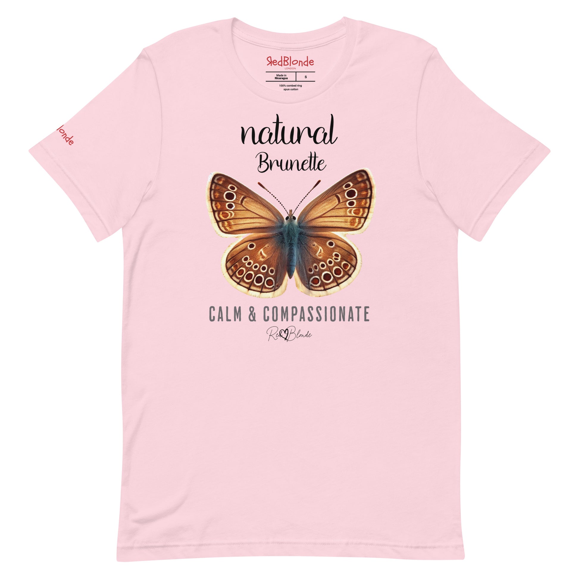 Flatlay of pale pink unisex relaxed fit t-shirt with the words natural brunette in arionna font above a graphic of a brunette brown butterfly with 'CALM & COMPASSIONATE' below in  adventurer 06 font signed off by RedBlonde. Branded RedBlonde London on inside neck and right sleeve