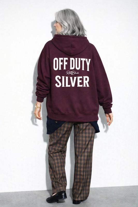 model wears Plum oversized hoodie shown from the back featuring large white “OFF DUTY SILVER” Brookfield text with a small RedBlonde script logo between the words.