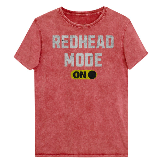 red denim-style unisex t-shirt with bold distressed white Univercity font reading “Redhead Mode” and a yellow on/off switch graphic in the “On” position beneath. The design includes subtle worn texture for a vintage look. Branded RedBlonde London in red on inside neck and right sleeve