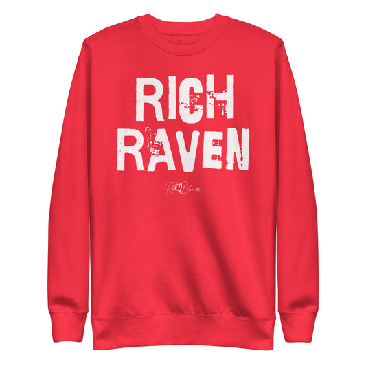 red unisex premium sweatshirt with bold distressed white Ed Geinitext “RICH RAVEN” on the front, featuring a subtle RedBlonde logo beneath the lettering and on the sleeve cuff and inside neck