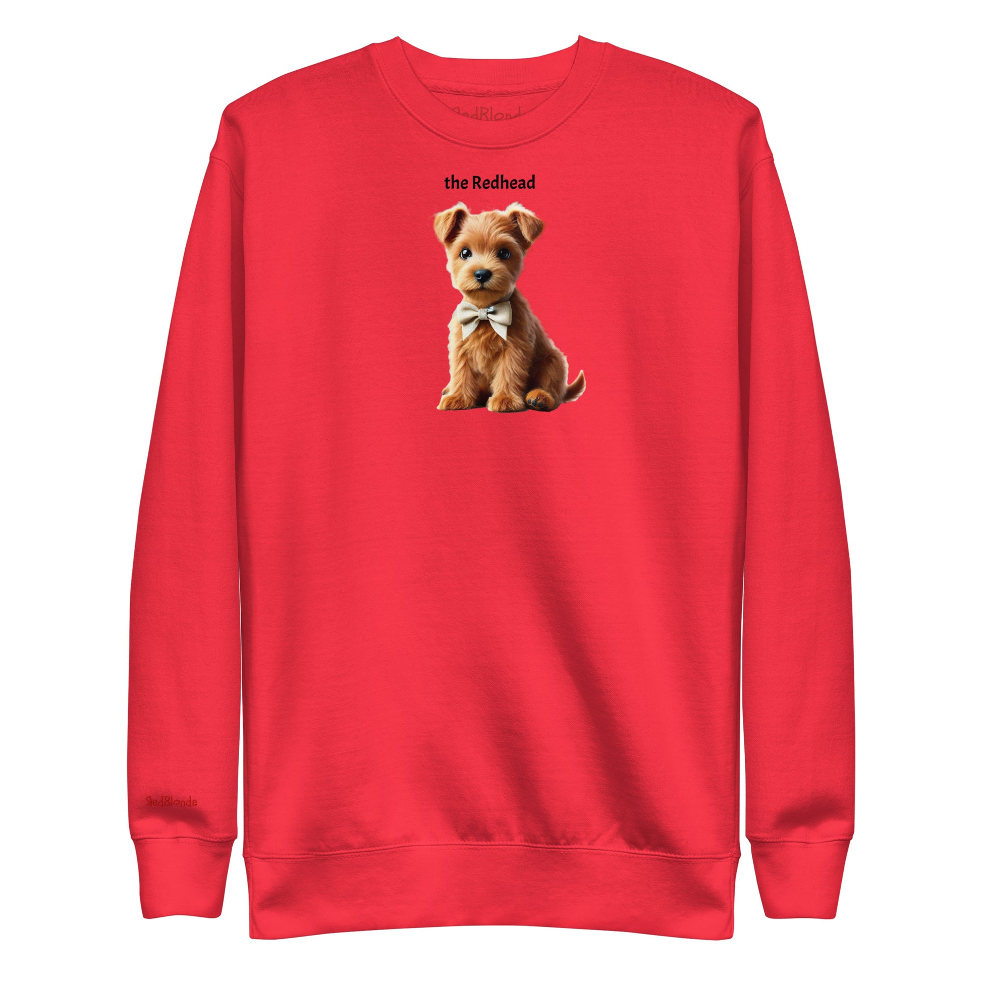 Flatlay of red relaxed fit unisex sweatshirt with a cute graphic of a Redhead Puppy wearing a bow-tie and the words 'the Redhead' linking to Red hair. Branded RedBlonde in red on inside neck and right cuff