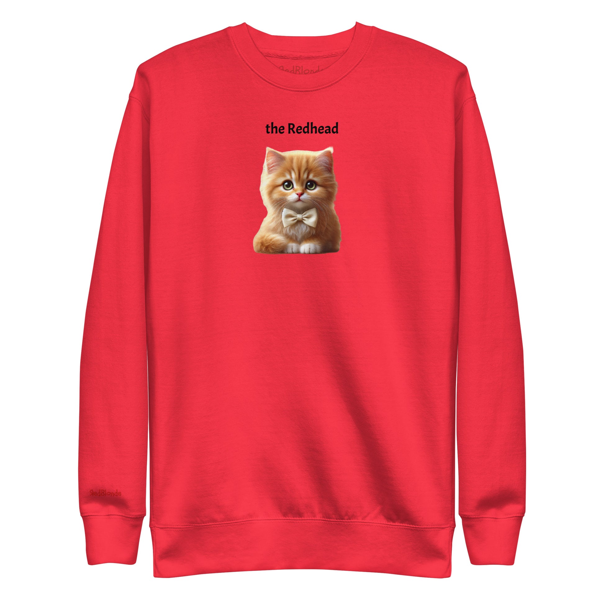 Flatlay of red relaxed fit unisex sweatshirt with a cute graphic of a redhead kitten wearing a bow-tie and the words 'the Redhead' linking to Red hair. Branded RedBlonde in red on inside neck and right cuff