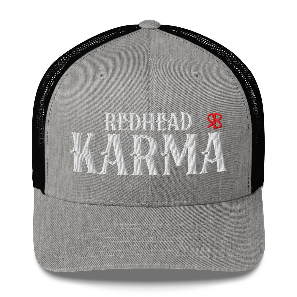 light grey/black retro trucker cap with mesh back. The front features bold white embroidered text reading "REDHEAD KARMA" with a small red RB logo to the right.
