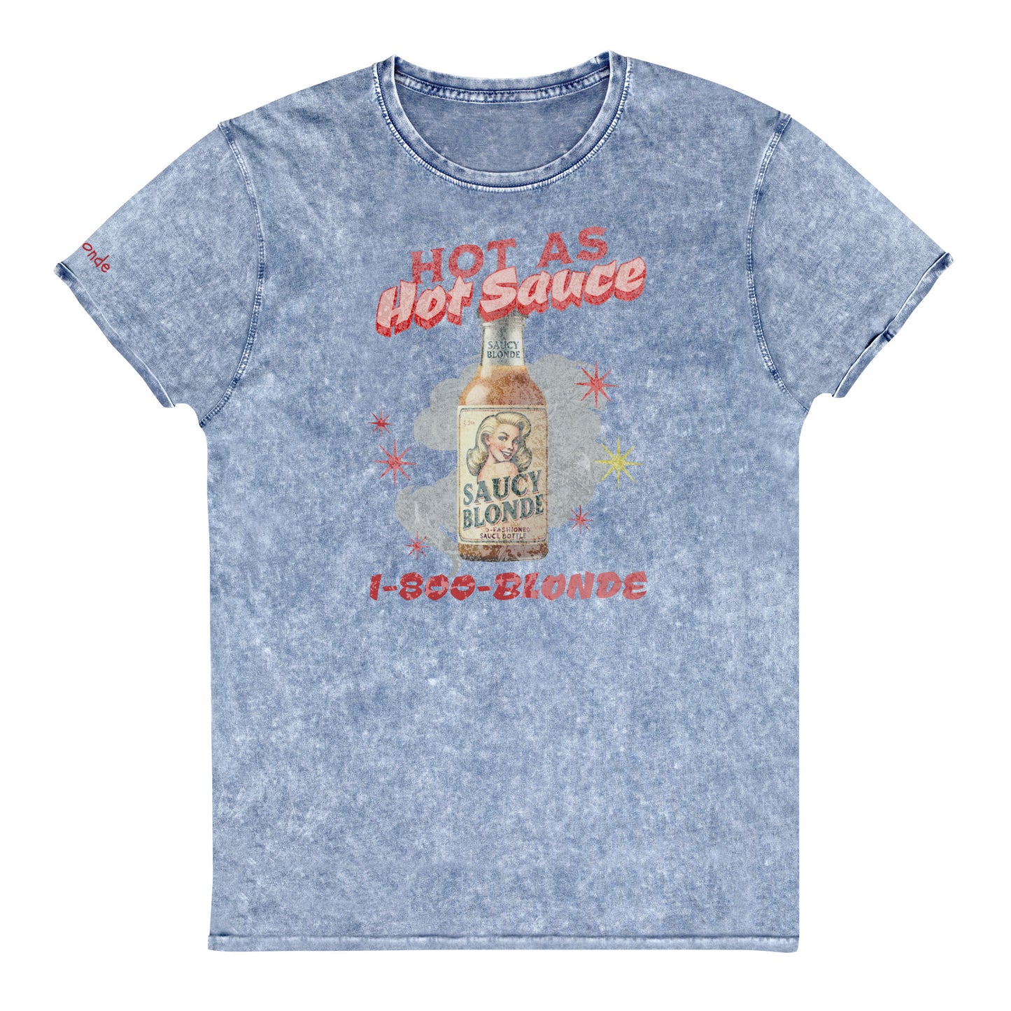 flatlay of a relaxed blue denim-wash t-shirt with a retro American-vintage pop-art graphic featuring a bottle of sauce with Saucy Blonde on it and the words Hot As hot Sauce. branded with redblonde london in red on the inside neck and right shoulder