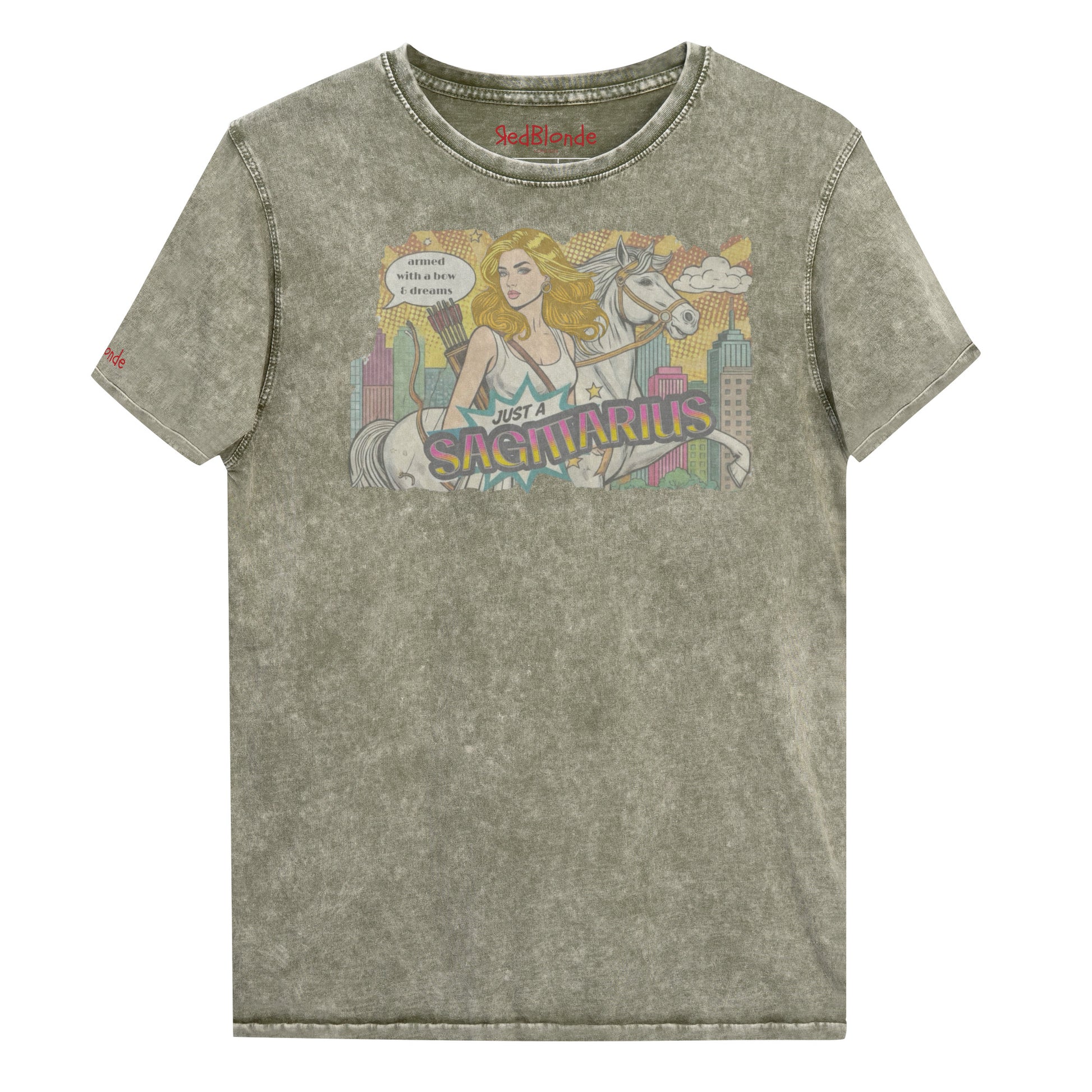 Flatlay of a unisex army green denim wash vintage t-shirt with a retro pop-art Blonde Sagittarius graphic featuring a blonde woman, with bow & arrows, white stallion, and a city backdrop, captioned ‘Just a Sagittarius, armed with a bow & dreams'. Branded RedBlonde on the inside neck and right sleeve