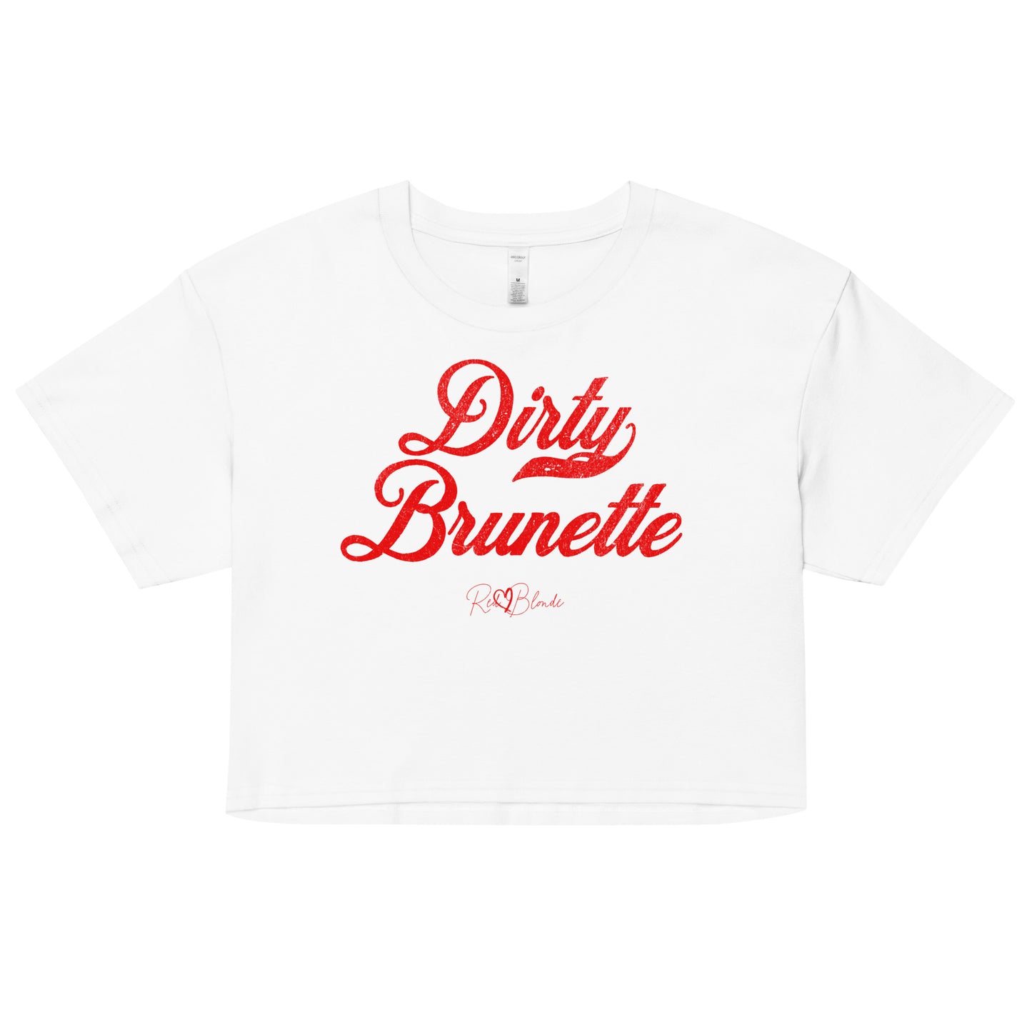 white women’s crop top featuring the phrase “Dirty Brunette” in bold, red milkstore vintage-style script across the chest. Below the phrase, the brand name “RedBlonde” is printed in a smaller, elegant handwritten font.