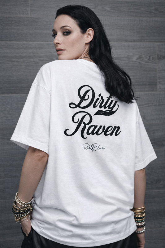 Back view of a white boxy oversized unisex T-shirt with bold black Milkstore 01 vintage-style script reading “Dirty Raven” and the RedBlonde signature logo beneath
