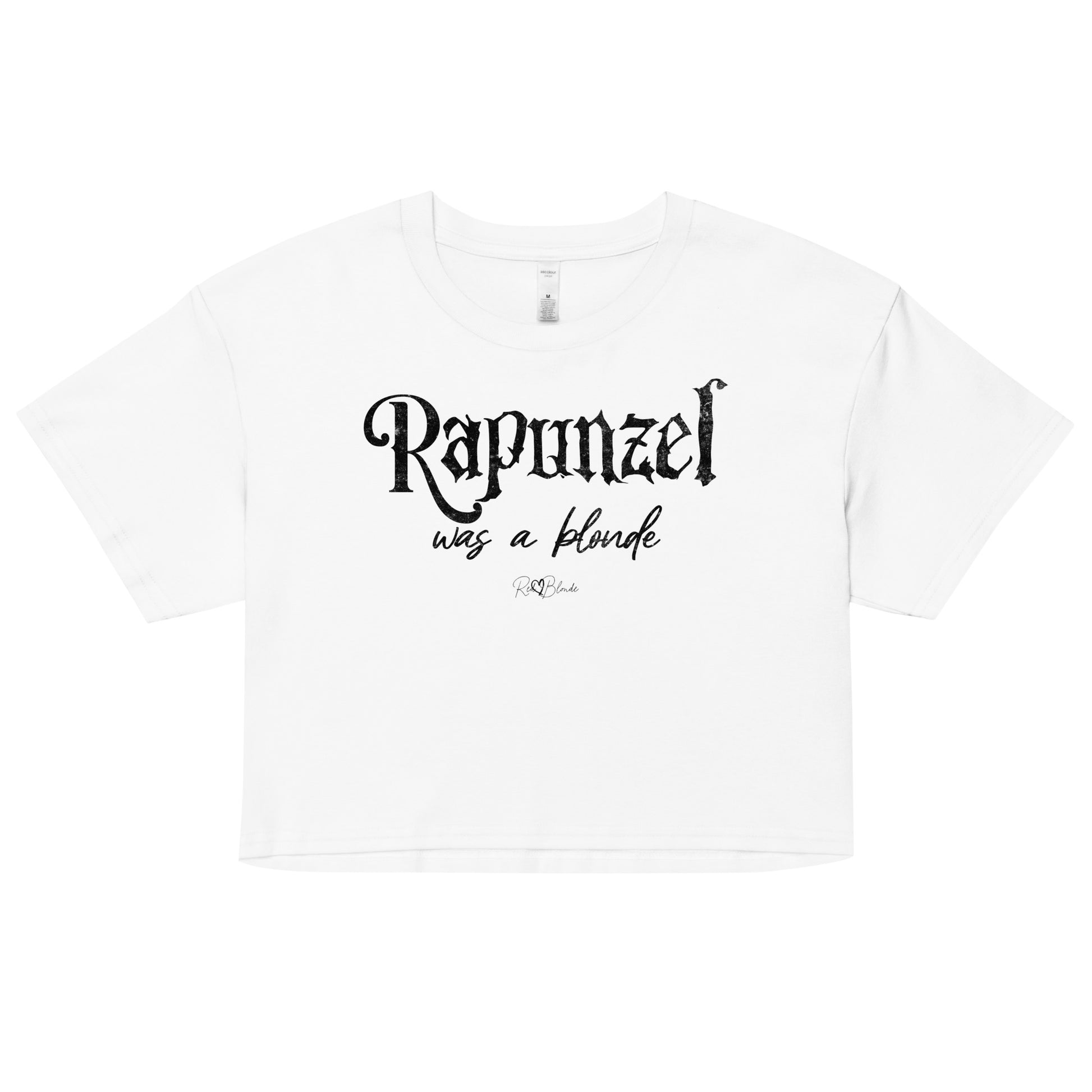 white women’s crop top featuring black fairytale spiky text that reads “Rapunzel" and the phrase “was a blonde” written underneath in an elegant cursive script. signed off with the RedBlonde heart signature logo