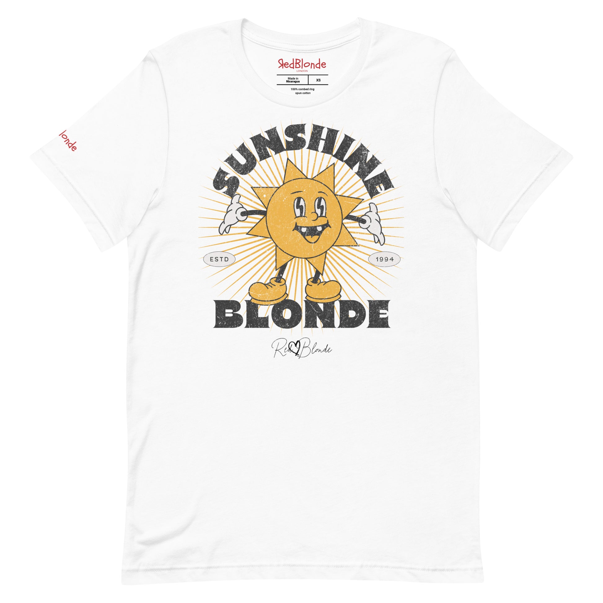 White unisex crew neck t-shirt with a retro cartoon-style yellow sun character, smiling with open arms, surrounded by radiant sunbeams. The text reads ‘Sunshine Blonde’ in bold vintage Belzebuth lettering, with small details including ‘ESTD 1994’ and the RedBlonde signature logo beneath."