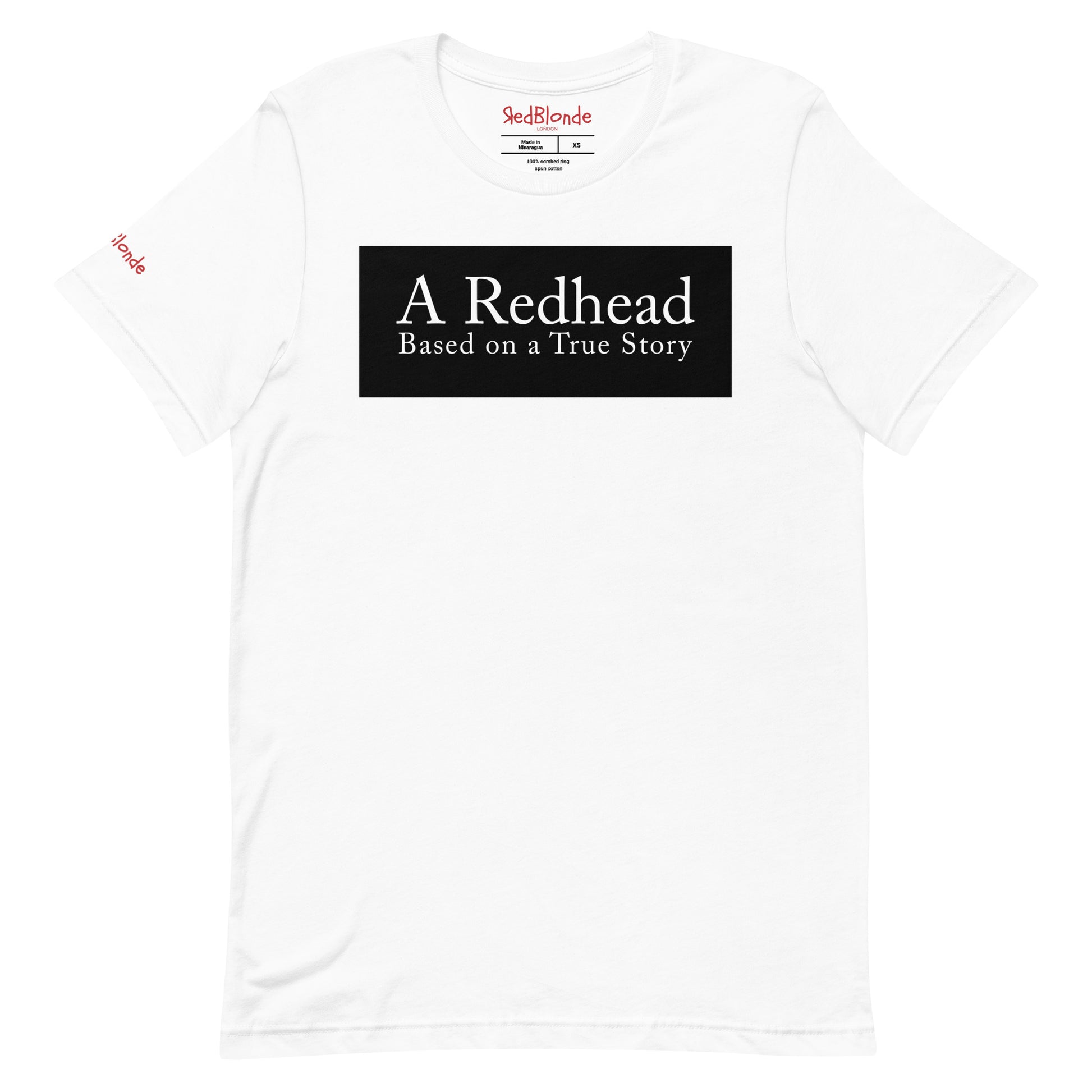 flatlay of a white unisex relaxed fit t-shirt with the slogan 'A Redhead. Based on a True Story' in white text in a black box graphic. Branded RedBlonde in red on inside neck and right shoulder