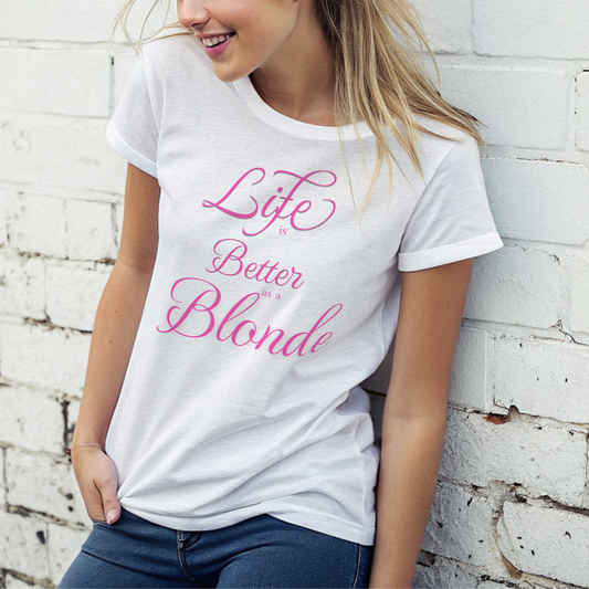 blonde model, leaning against wall, wears jeans and a white unisex relaxed fit t-shirt with the slogan 'life is better blonde' in pink. 